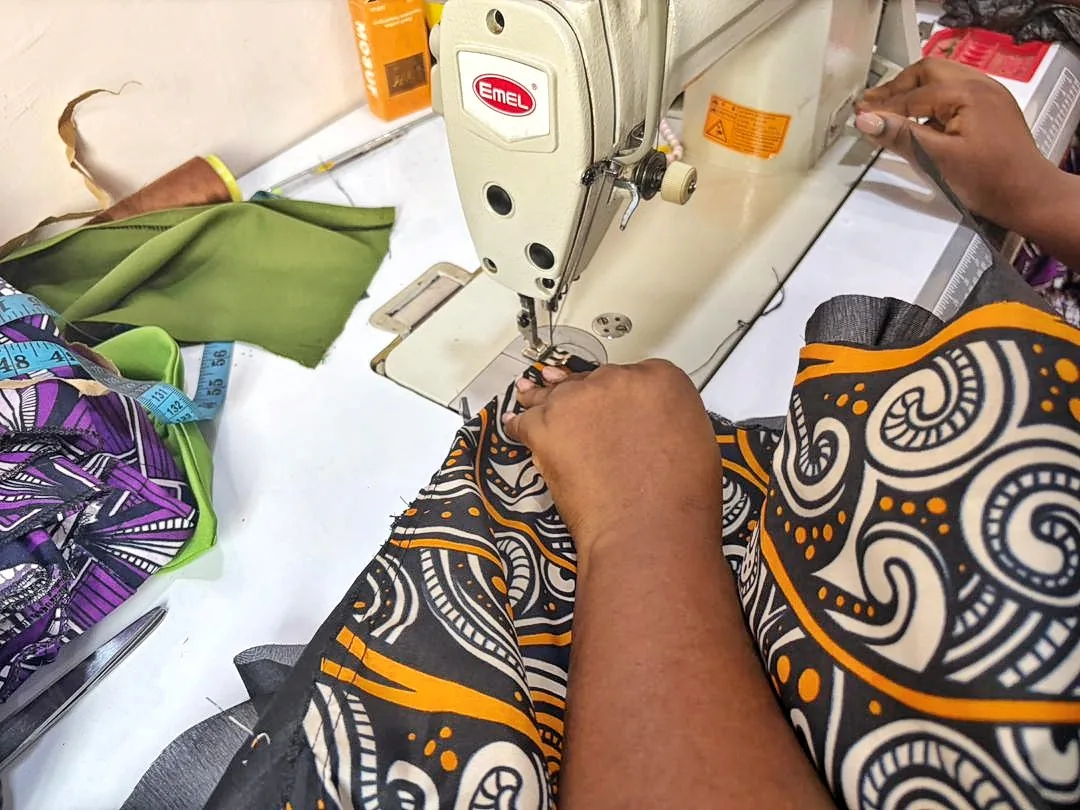 Couturière assemblant un textile imprimé à la machine dans son atelier.