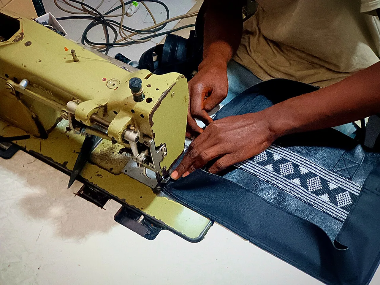 Artisan travaillant un sac à la machine à Soumbédioune, au Sénégal.